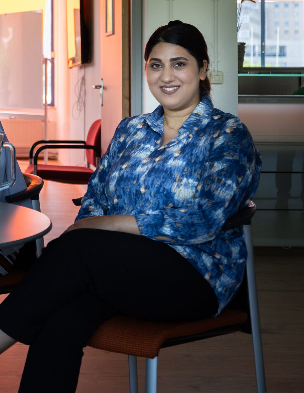 Drie jonge vrouwen zitten aan tafel in Lokaal 1 bij Lest Best, klaar voor de cursus Nederlands op A1-niveau.